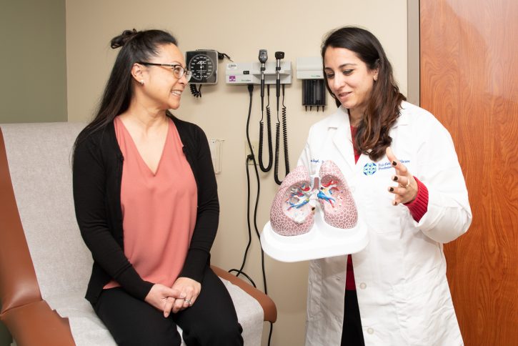 Dr. Avneet Singh discusses a model of the lungs with a patient